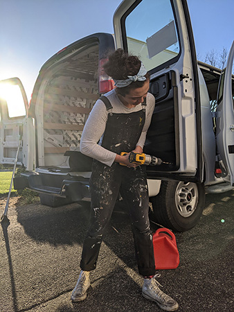 Rachel drilling out the facotry panels in her van.