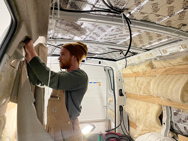 Tyler uphostering the interior of a van.